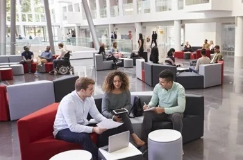 Students sitting on couches in a university's atrium.